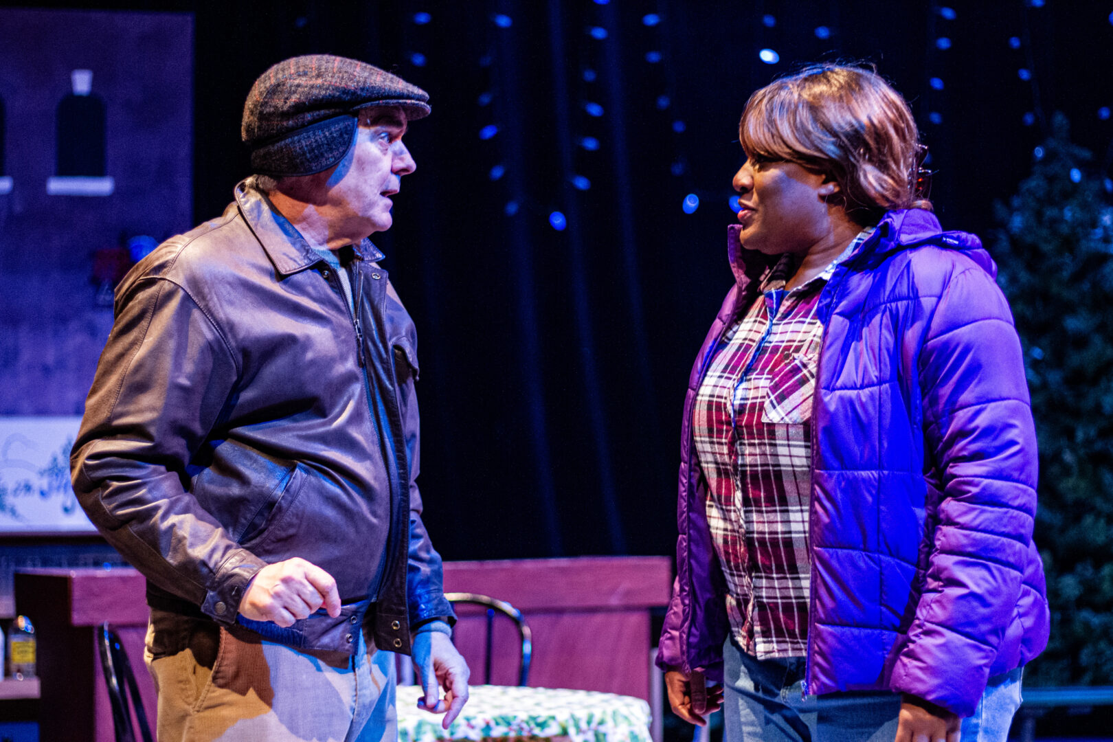 A man and woman in winter coats have a conversation.