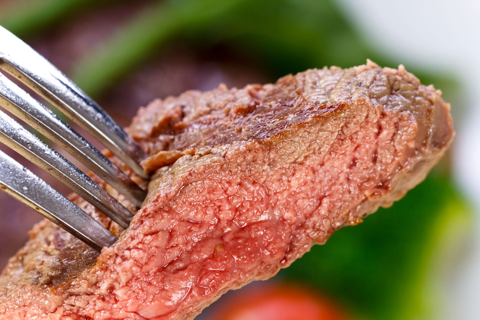 A piece of New York Strip Steak on a fork.