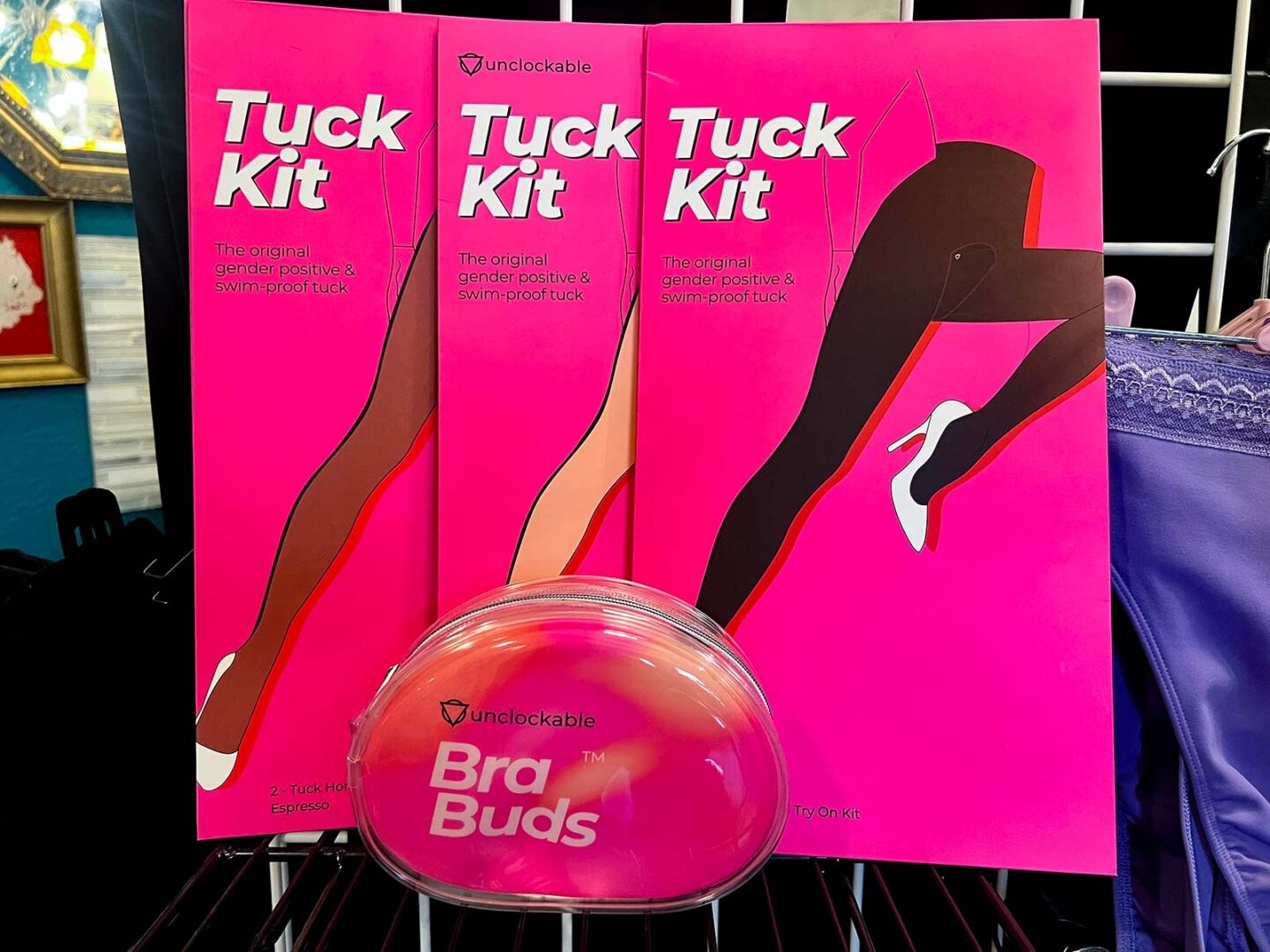 3 different colors of Tuck Kit products hanging on a rack.