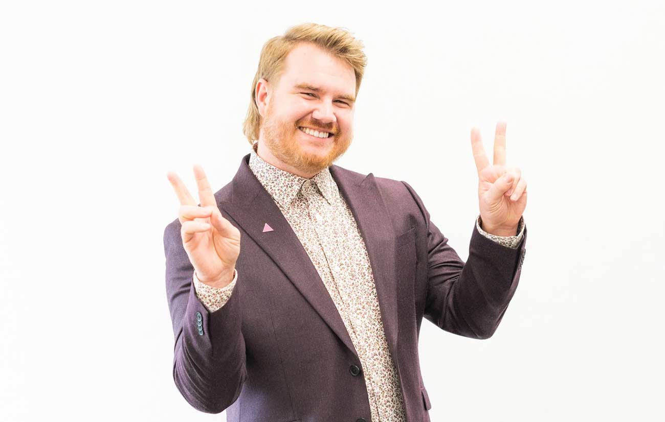 Dylan Boyer poses with his hands making the peace sign.