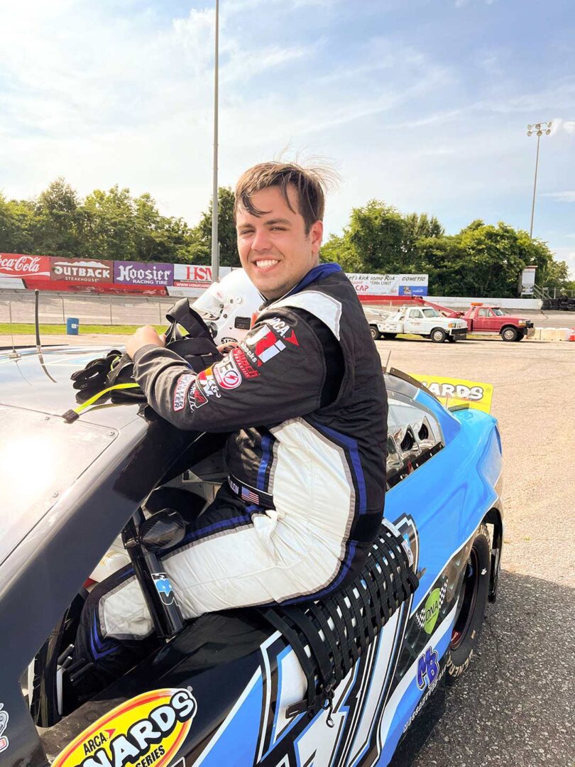 Motorsports athlete Michael Klein sitting in the window of his race car.