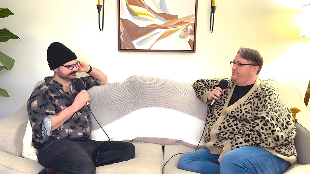 Gay podcasters doing a show on their couch.