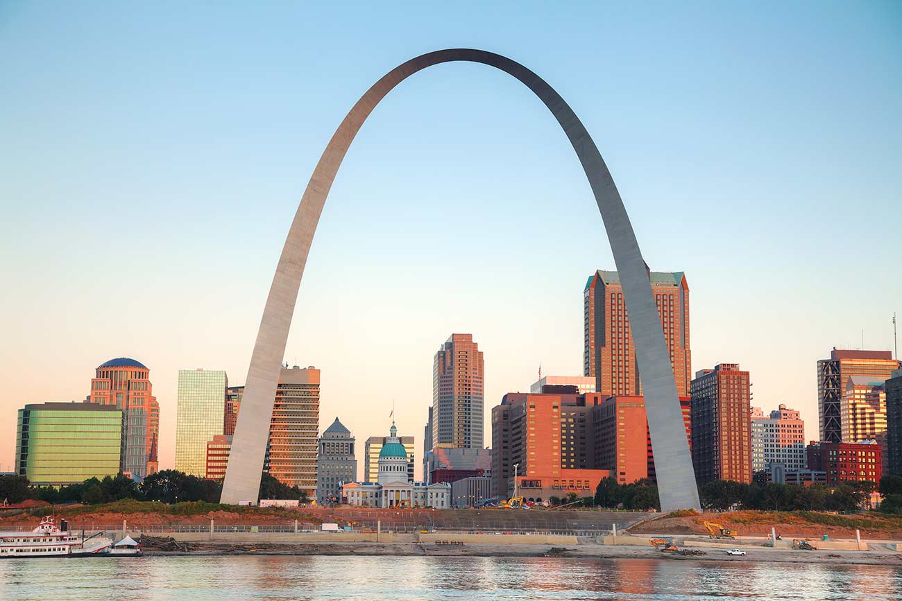 Downtown St Louis MO with the Old Courthouse and the Gateway Arch at sunrise.