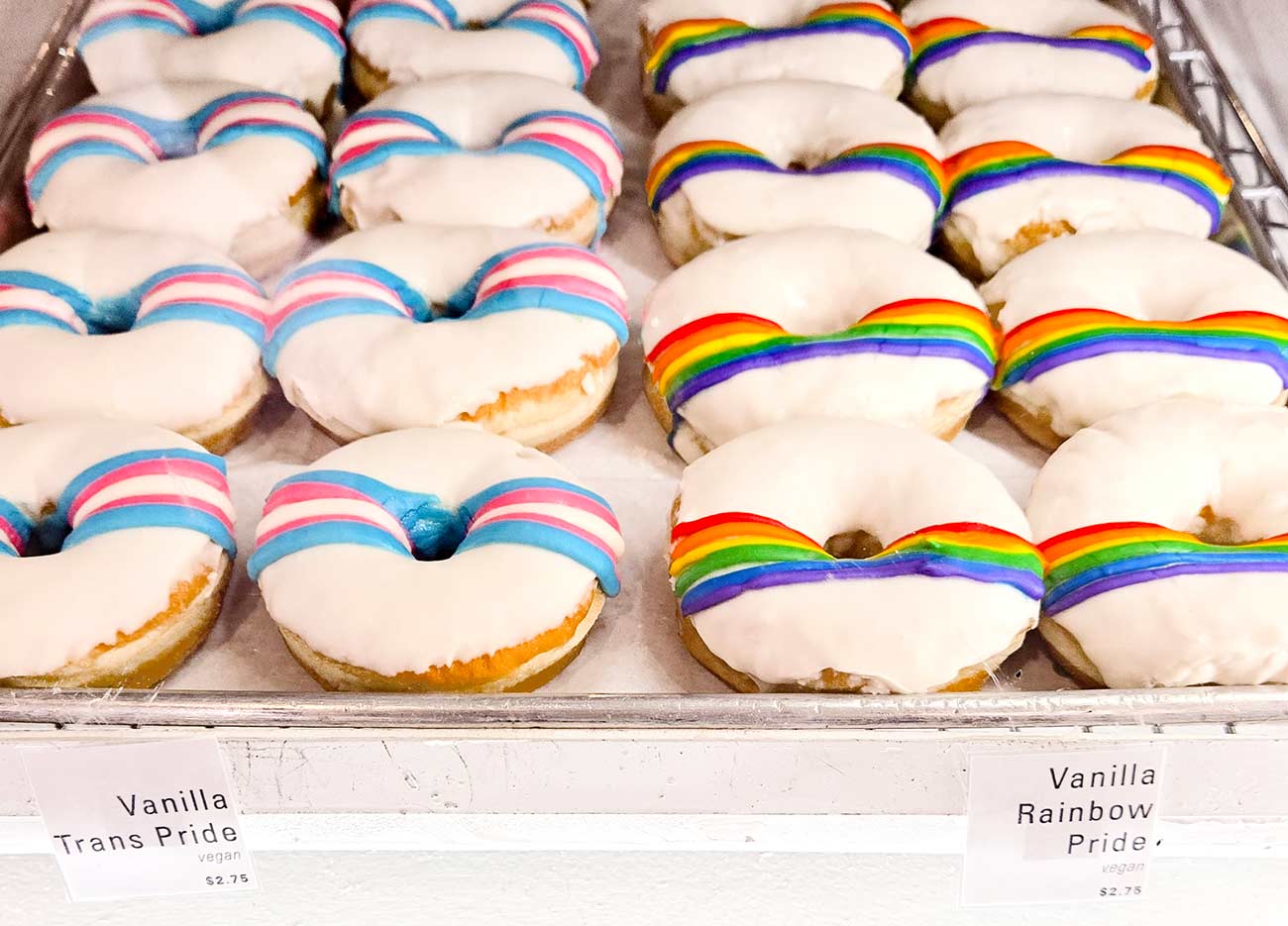 Trans and rainbow striped on white frosted donuts at Strange Matter Coffee.
