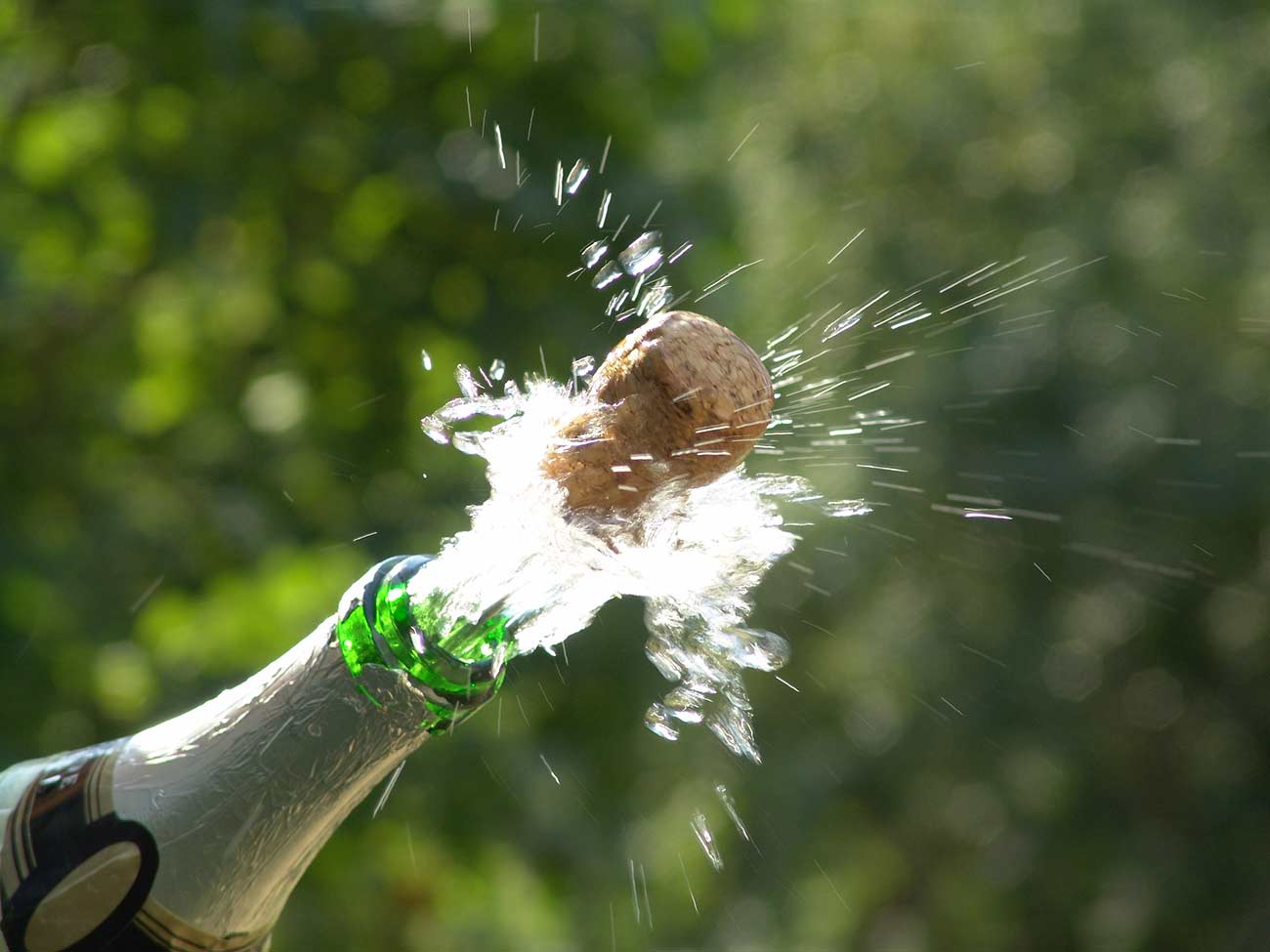 Sparks of champagne as the cork pops out.