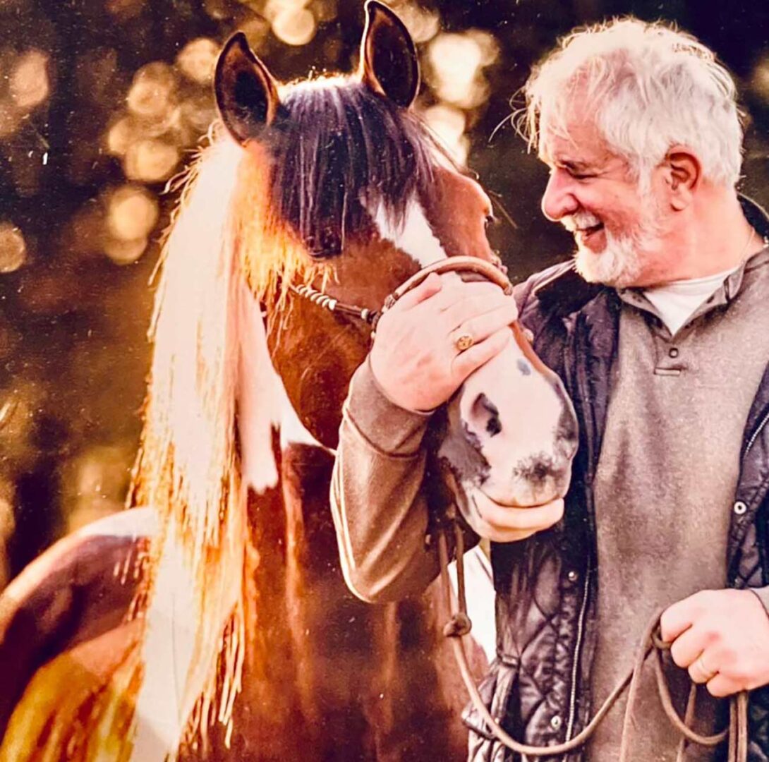 Author Tom Equels holding the nose alongside his horse.