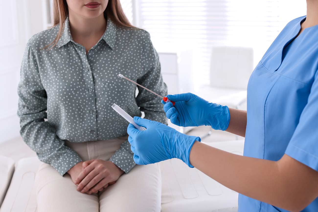 Woman in clinic with a doctor taking sample for testing.