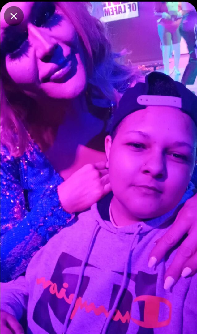 Sam Nordquist posing with a drag queen at a nightclub.