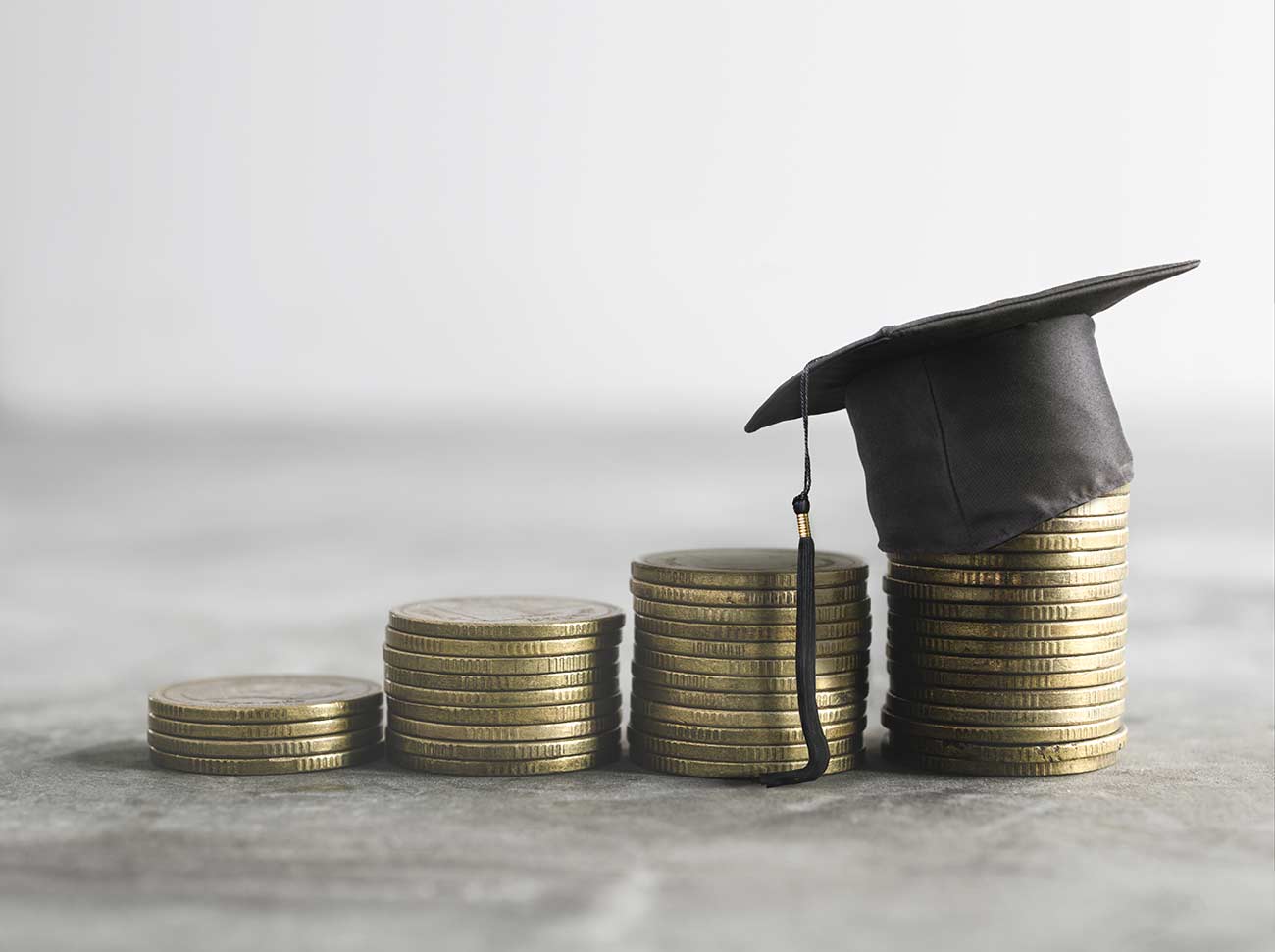 Graduate hat on top of scholarship money concept.